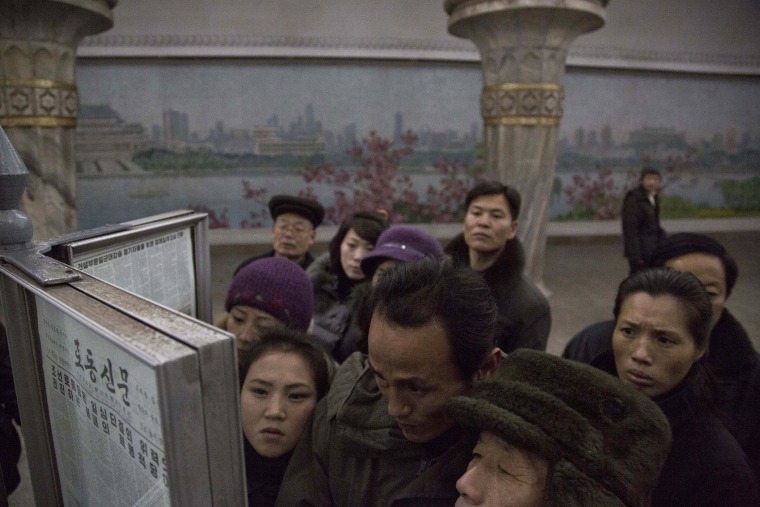 North Korean subway commuters gather around a public newspaper stand on the train platform in Pyongyang, North Korea on Dec. 13, 2013 to read the headlines about Jang Song Thaek, North Korean leader Kim Jong Un's uncle who was executed as a traitor.