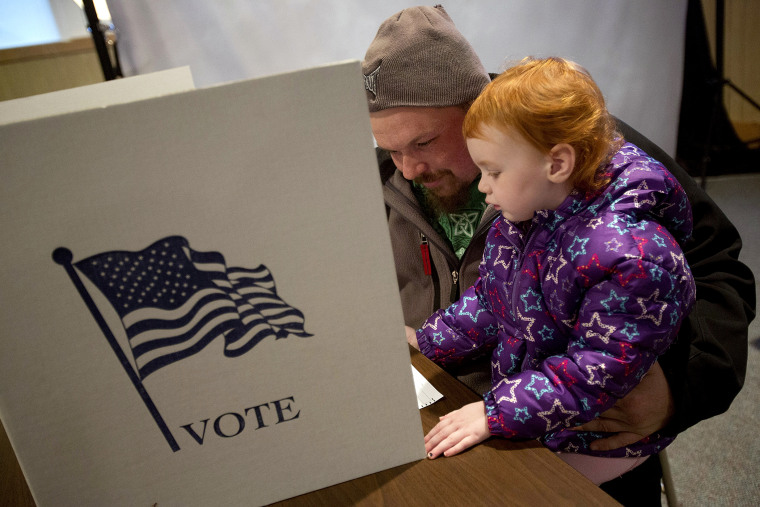 Dallas Seitz of Zwingle, Iowa fills out his ballot with his daughter, Madeline, 3, at the Saint Lawrence Church on November 6, 2012 in Otter Creek, Iowa.