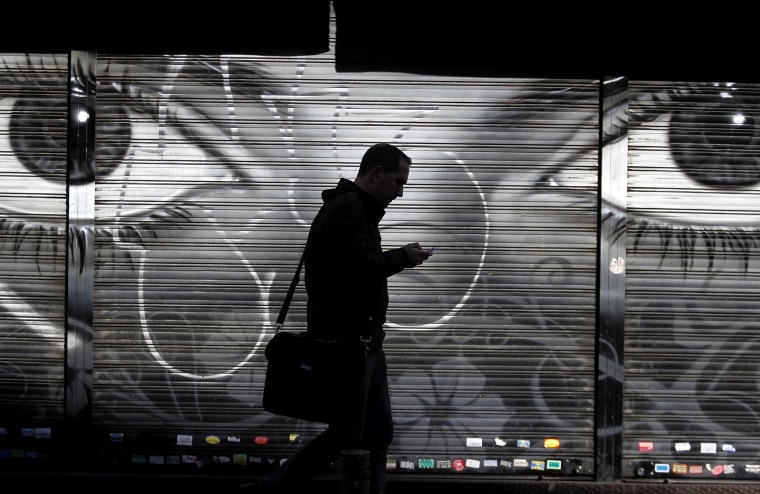 A man looks at his cell phone as he walks on the street in downtown Madrid, Oct. 31, 2013.