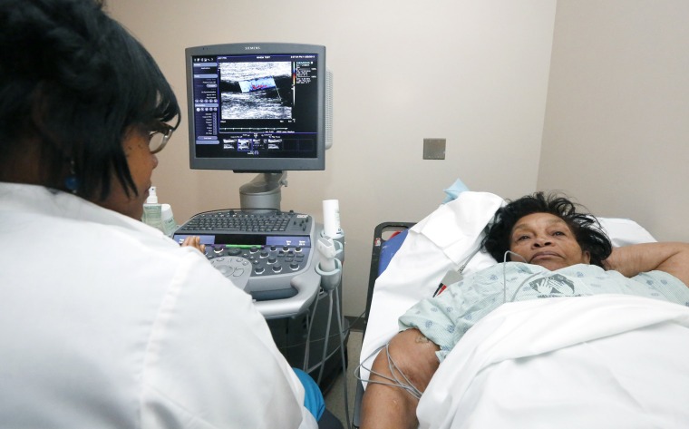 In this Nov. 25, 2013 photograph, Alberta Epps of Jackson, Miss., right, undergoes a sonogram of the brachial artery.