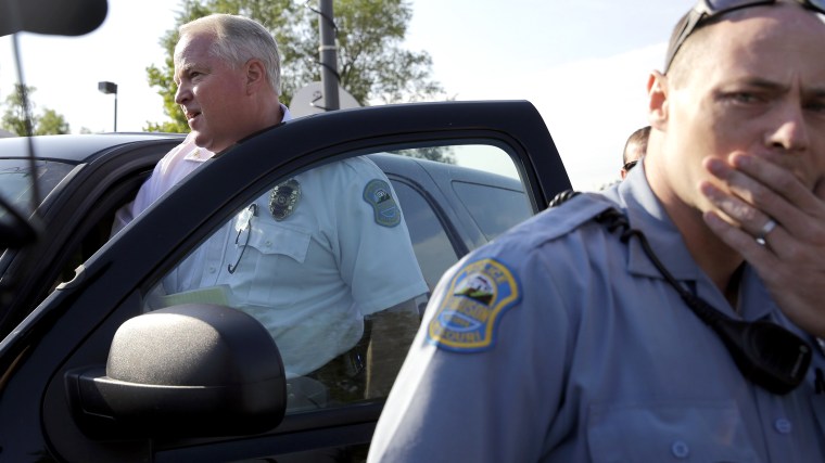 Ferguson Police Chief Thomas Jackson, left, gets in a vehicle to drive away after a news conference on Aug. 15, 2014, in Ferguson, Mo.