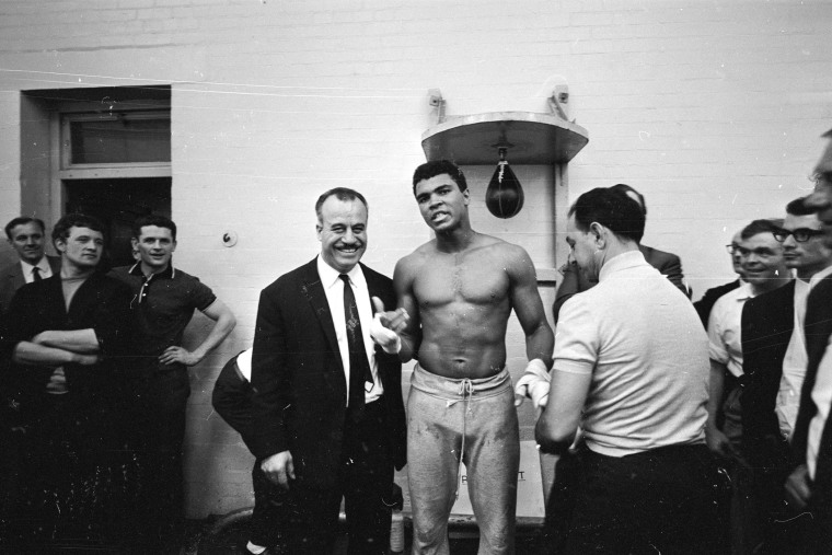 World heavyweight boxing champion Muhammad Ali has his hands bandaged by his manager Angelo Dundee before the day's training session at the Territorial Army Gymnasium at White City, London on May 16, 1966. (R. McPhedran/Express/Getty)