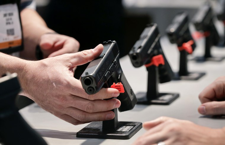 A Glock representative explains features of the Glock 37 Gen 4 .45 caliber pistol at the 35th annual SHOT Show, Jan. 16, 2013, in Las Vegas.