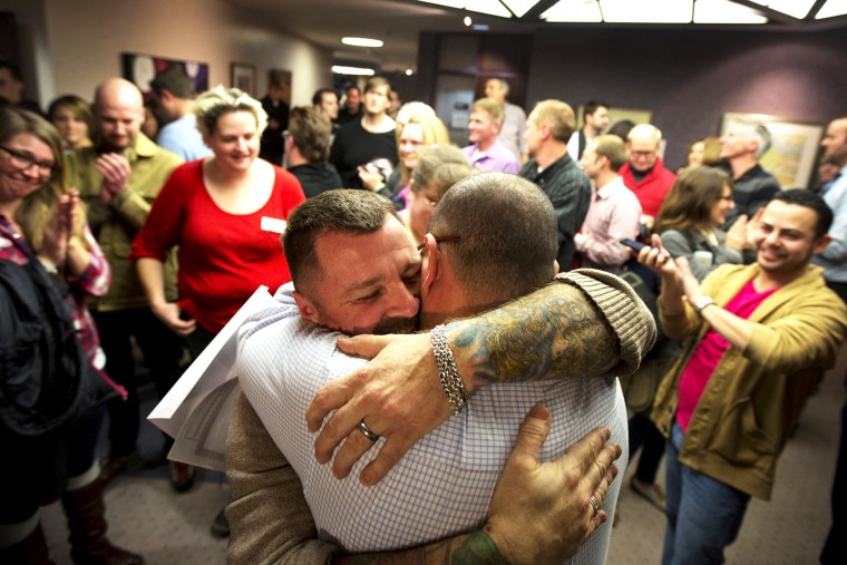 Image: Chris Serrano, left, and Clifton Webb embrace after being married, as people wait in line to get licenses outside of the marriage division of the Salt Lake County Clerk's Office in Salt Lake City, Friday, Dec. 20, 2013