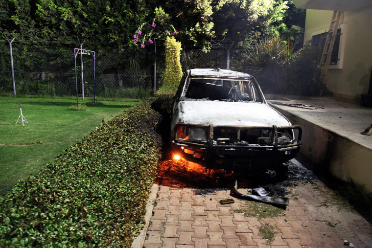 A burnt out vehicle sits smoldering in flames after it was set on fire inside the US consulate compound in Benghazi, Sept. 11, 2012.