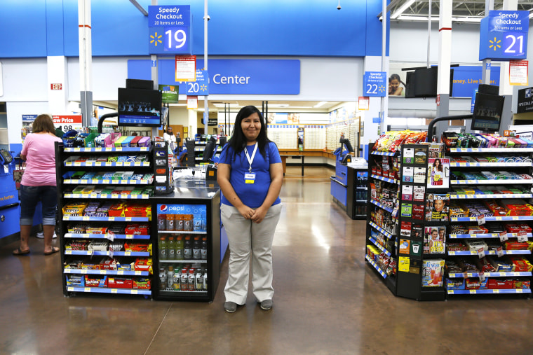 A cashier waits for customers at a Walmart Supercenter in Rogers, Arkansas June 6, 2013.