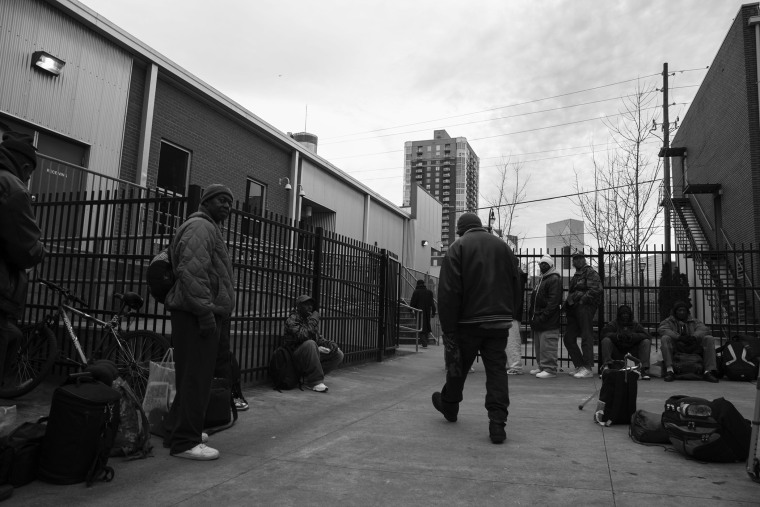 Homeless men line up in the courtyard of The Shepherd’s Inn men’s shelter in Atlanta, Georgia, waiting to get assigned a bed for the night.