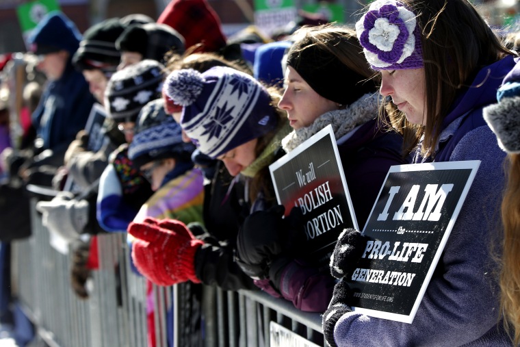Anti-abortion demonstrators bow their heads in prayer on the National Mall in Washington, Jan. 22, 2014, during the annual March for Life.