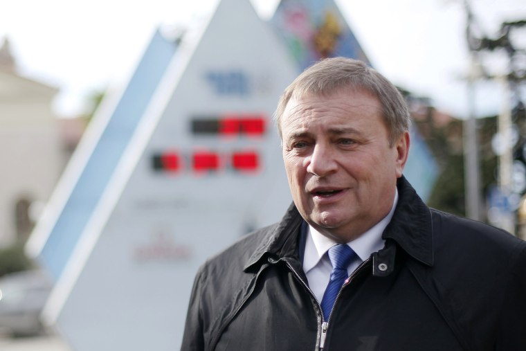 Sochi's Mayor Anatoly Pakhomov stands with the count-down clock to the Olympics on Jan. 31, 2013.