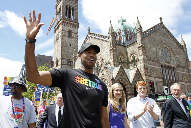 NBA veteran Jason Collins, left, marches in Boston's gay pride parade, June 8, 2013.