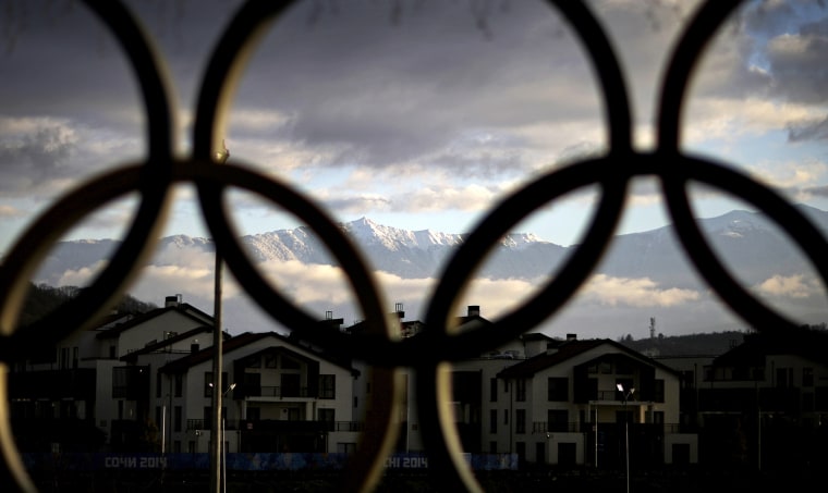 The Caucasus Mountains seen through the Olympic rings over the athlete's village in the coastal cluster, Feb. 2, 2014, in Sochi, Russia.