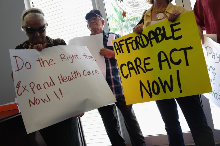 Leonor Cervantes (L) and other protesters gather in the office of Florida State Rep. Manny Diaz as they protest his stance against the expansion of healthcare coverage on September 20, 2013 in Miami, Florida.