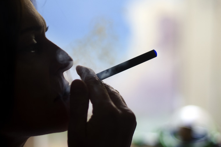 This Sept. 25, 2013 photo illustration taken in Washington, DC, shows a woman smoking an \"Blu\" e cigarette.