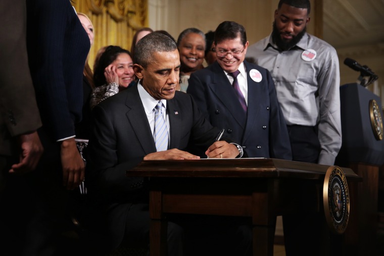 U.S. President Barack Obama signs an executive order to raise the minimum wage for federal contractors, Feb. 12, 2014.
