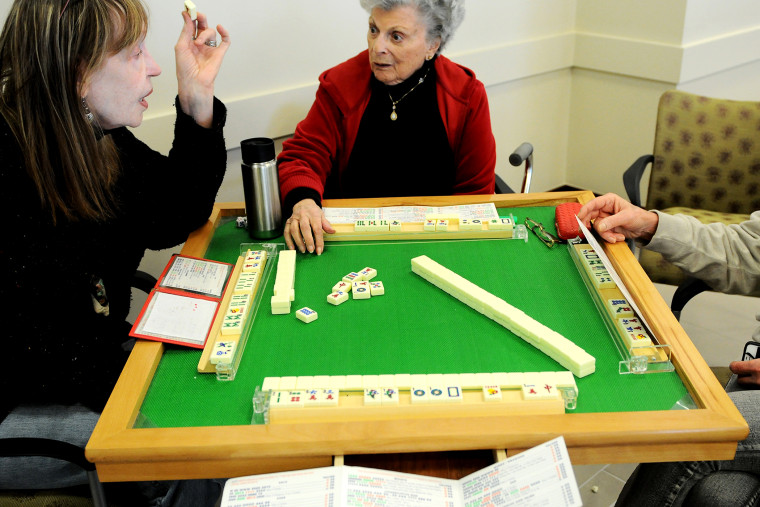 John C. Anderson residents take in a game of Mahjong in the community room.