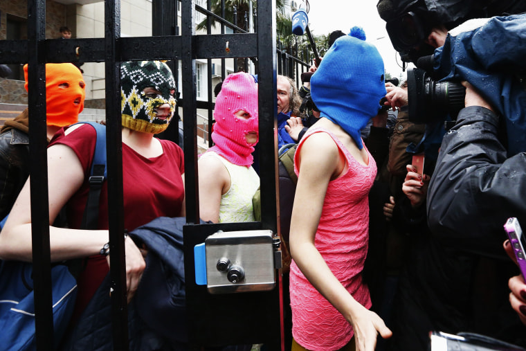 Masked members of Pussy Riot leave a police station in Adler during the 2014 Sochi Winter Olympics, Feb. 18, 2014.