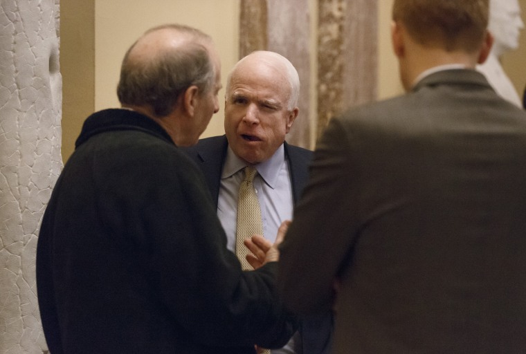 Sen. John McCain, R-Ariz., holds a meeting in the hallway outside the Senate chamber on Capitol Hill in Washington, Wednesday, Feb. 12, 2014.