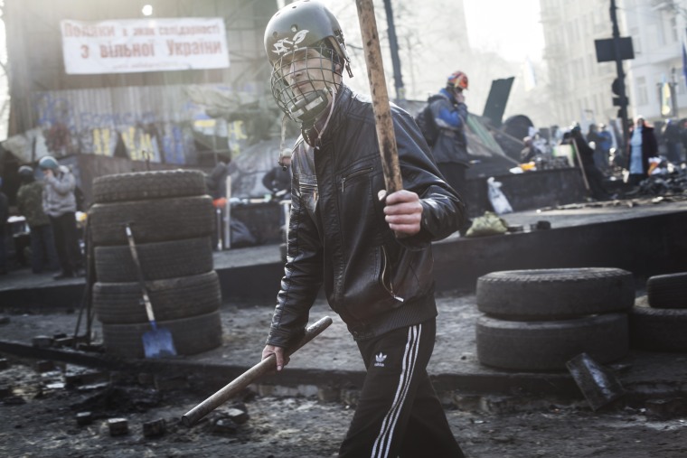 Anti-government protester walks by the barricade on Hrushevskoho street near Maidan Square in Kiev, Feb. 21, 2014.