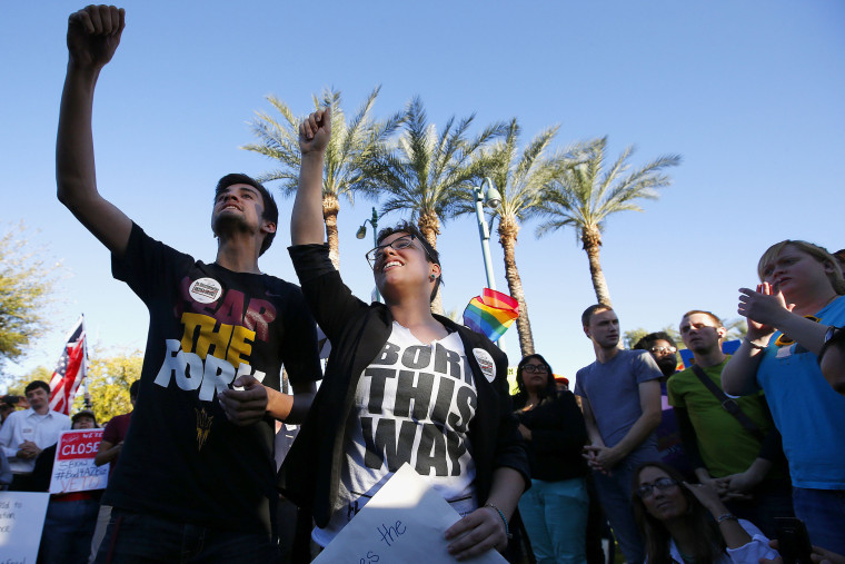 Anthony Musa, left, and Brianna Pantillione join nearly 250 gay rights supporters protesting SB1062 at the Arizona Capitol, Friday, Feb. 21, 2014, in Phoenix.