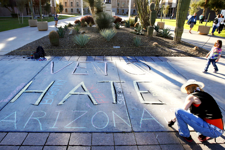 Margaret Jean Plews works on a chalk drawing as she joined nearly 250 gay rights supporters protesting SB1062 at the Arizona Capitol, Feb. 21, 2014.