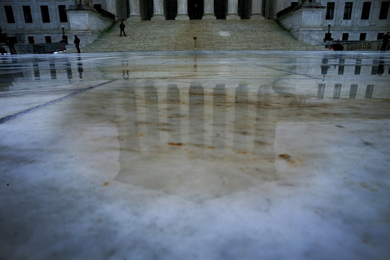 Rain water reflects the U.S. Supreme Court building in Washington, Dec. 9, 2013.