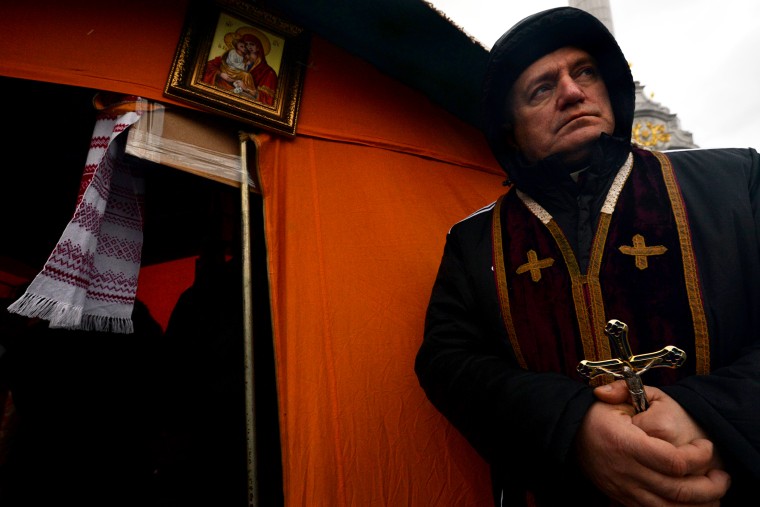 A priest of the Greek Catholic Church holds a crucifix on Independence Square in Kiev, Dec. 7, 2013.