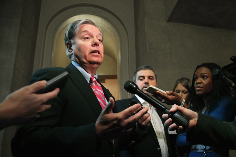 Sen. Lindsey Graham talks to reporters after leaving a Senate Republican caucus meeting at the U.S. Capitol October 11, 2013 in Washington, DC.