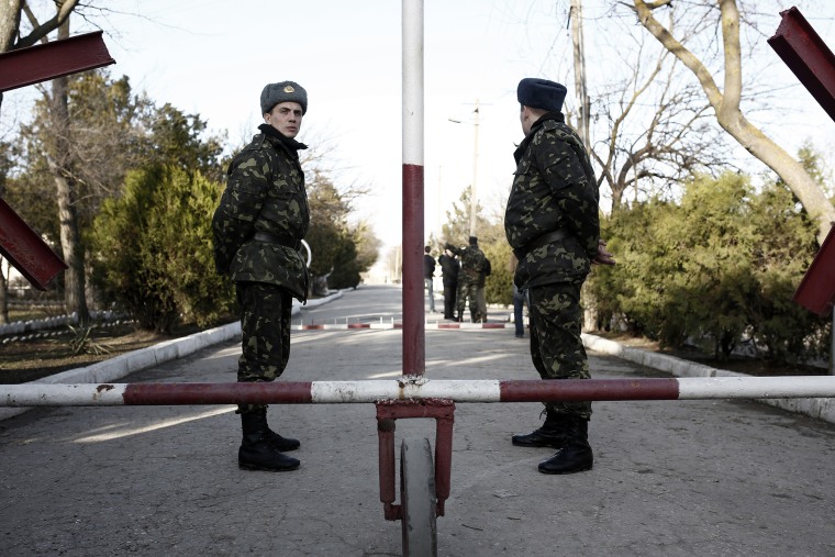 Ukrainian soldiers wait in front of the main entrance of the barracks at the Ukrainian military base in Eupatoria, taken under control by Russian army forces in Crimea on March 5, 2014.