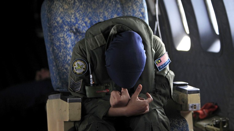 A crew member of a Royal Malaysian Air Force CN-235 aircraft rests after long hours working in a search and rescue operation for the missing Malaysia Airlines plane over the Straits of Malacca, Thursday, March 13, 2014.