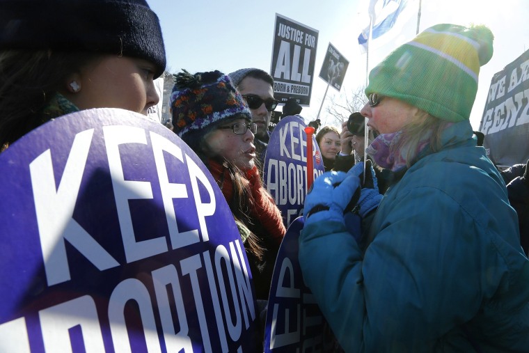 An anti-abortion demonstrator (R) shouts at pro-choice demonstrators (L) in front of the U.S. Supreme Court during the annual March for Life in Washington, January 22, 2014.