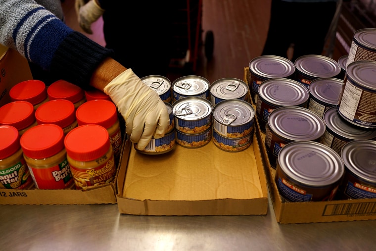 A volunteer distributes food at CAMBA's Beyond Hunger Emergency Food Pantry on Feb. 18, 2014 in the Brooklyn borough of New York City.