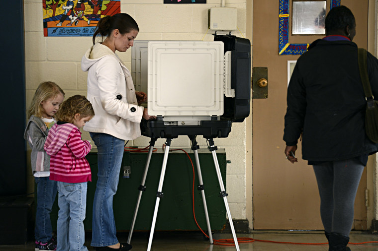 Ashley Zorman votes while her daughters Erica Zorman, left, and Keira Zorman, look on at Little Creek Elementary School in Norfolk, Va.  on Tuesday, Nov.  6, 2012.