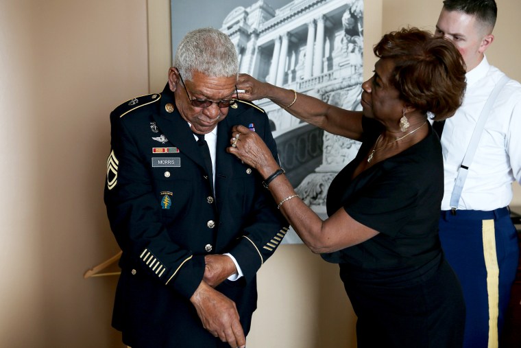 Mary Morris helps her husband U.S. Army Staff Sgt. (Ret.) Melvin Morris, a Vietnam War veteran, with his uniform as they prepare to make their to the White House on March 18, 2014.