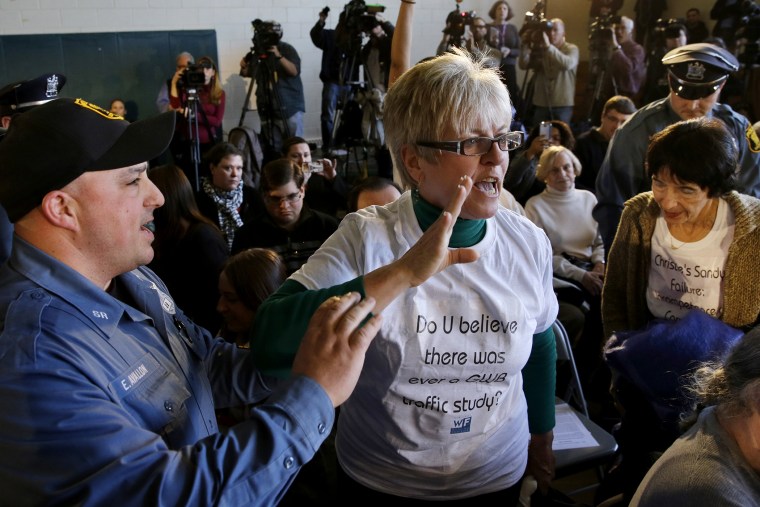 A woman shouts at New Jersey Gov. Chris Christie as South River police officers remove her from a town hall meeting on March 18, 2014 in South River, N.J.