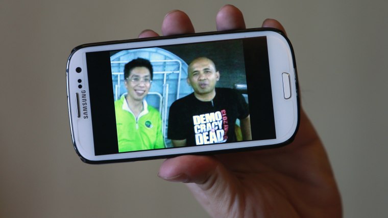 Peter Chong holds a smartphone displaying a picture of himself with missing Malaysia Airlines Flight MH370 captain Zaharie Ahmad Shah (R) during an interview with Reuters at a hotel in Sepang on March 18, 2014.