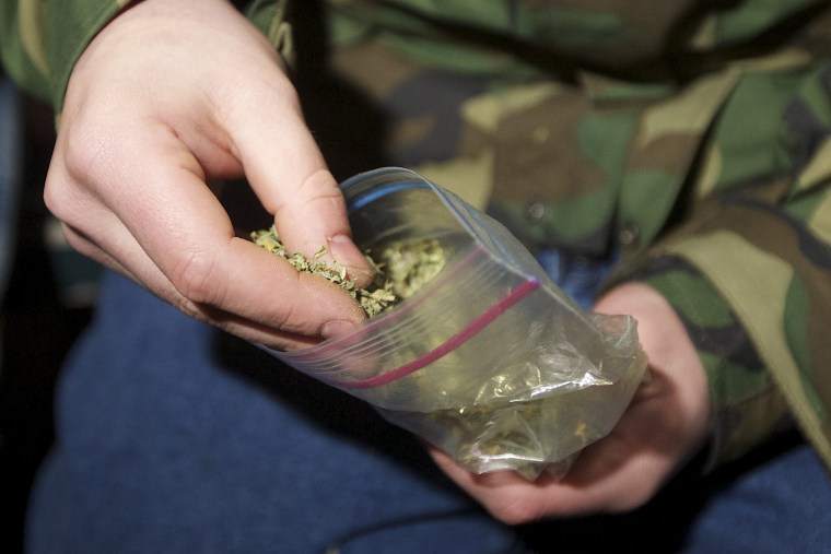 A Seattle resident takes marijuana from a plastic bag shortly after a law legalizing the recreational use of marijuana took effect on Dec. 6, 2012 in Seattle, Washington.