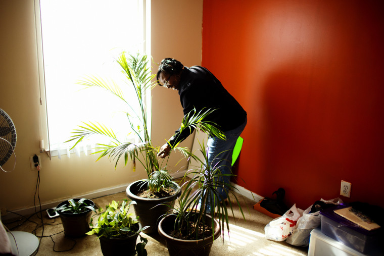 Renee Brooks waters plants in her home.