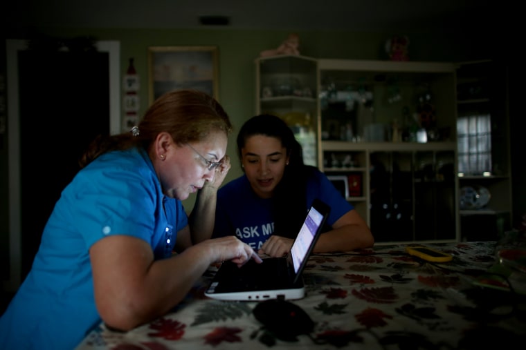 Janelle Arevalo (R), makes a house call to sign up Sandra Berrios for an insurance plan under the Affordable Care Act on Nov. 14, 2013 in Miami, Fla.