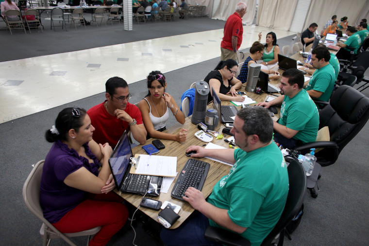 People try to purchase health insurance under the Affordable Care Act at a store setup in the Mall of Americas on March 20, 2014 in Miami, Florida.