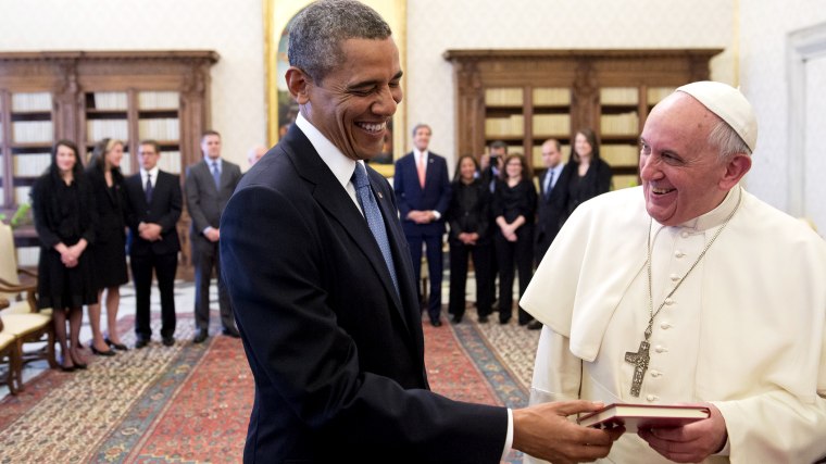 Pope Francis (R) and US President Barack Obama laugh as they exchange gifts during a private audience on March 27, 2014 at the Vatican.