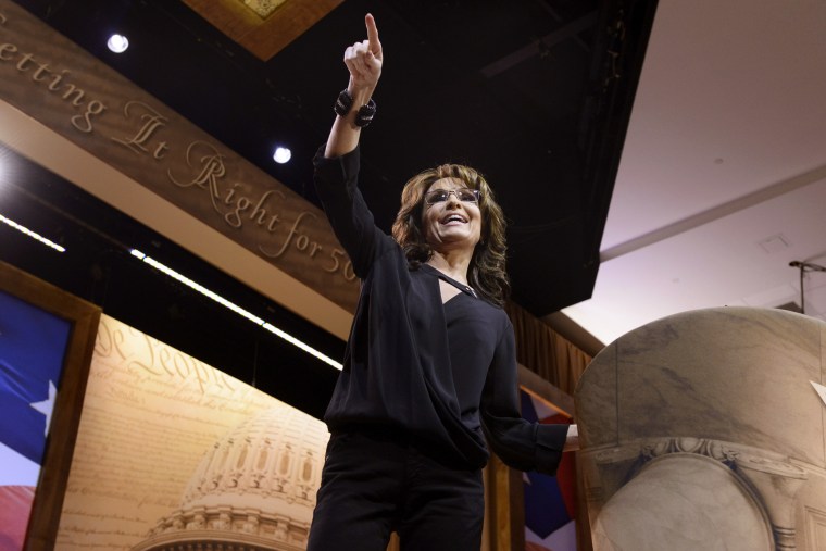 Former Alaska Governor Sarah Palin greets guests as she arrives to address the Conservative Political Action Conference, March 8, 2014, in National Harbor, Md.