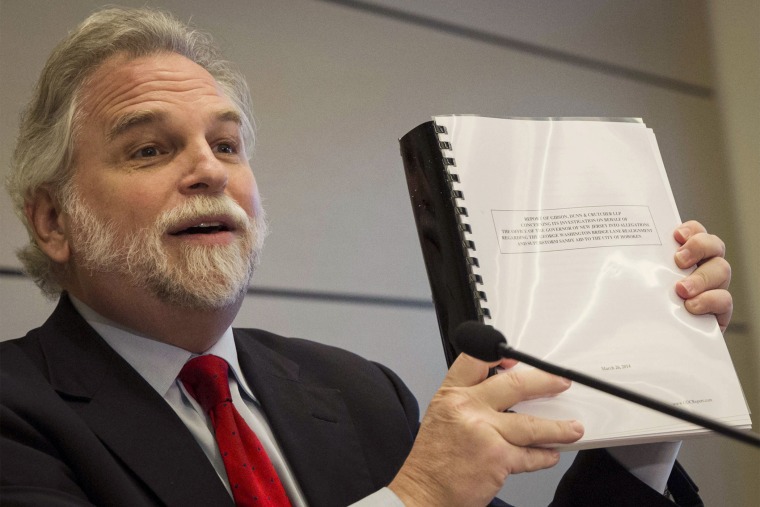 Attorney Randy Mastro holds up a copy of his report during a news conference, Thursday, March 27, 2014, in New York.