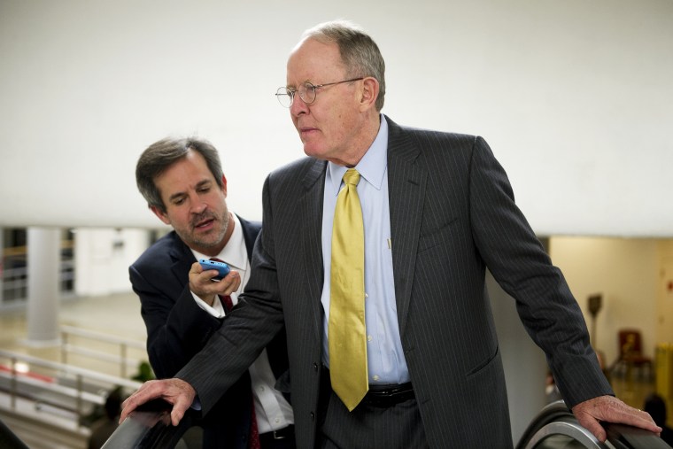 Sen. Lamar Alexander talks with reporters on the way to the Senate policy luncheons in the U.S. Capitol, Jan. 14, 2014.