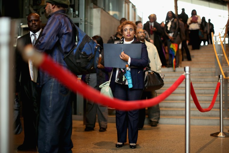 Almaz Mekonnen (C) stands in line with some of the 1,500 people seeking employment during a job fair in Washington, DC. Mar. 28, 2014.