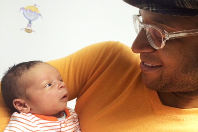 Craig Melvin holds his son, Delano Joseph Melvin.