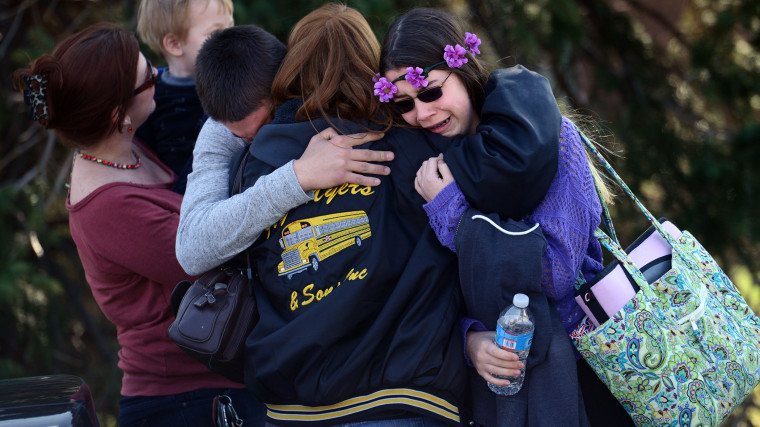 Parents and students embrace along School Road near Franklin Regional High School after more than a dozen students were stabbed by a knife wielding suspect at the school on Wednesday, April 9, 2014, in Murrysville, Pa., near Pittsburgh.