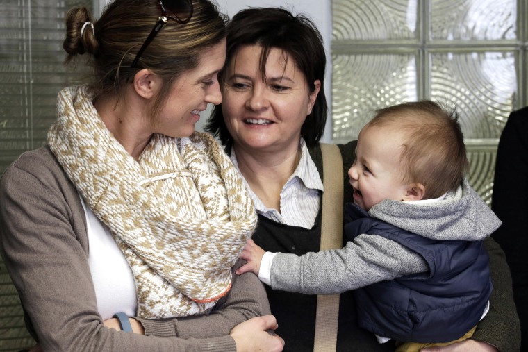 Amanda Broughton, left, looks at one of her twin sons being held by her partner Michele Hobbs, on Feb. 10, 2014, during a news conference in Cincinnati.