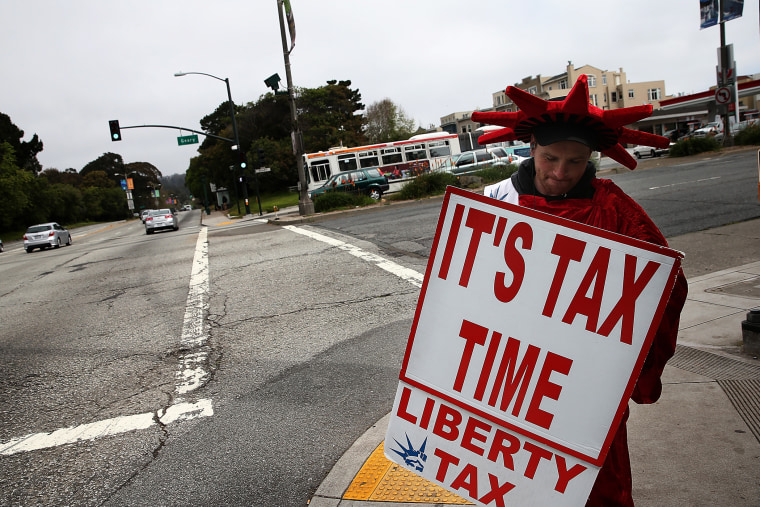 Aaron Lee holds a sign advertising income tax services for Liberty Tax Service on April 14, 2014 in San Francisco, California