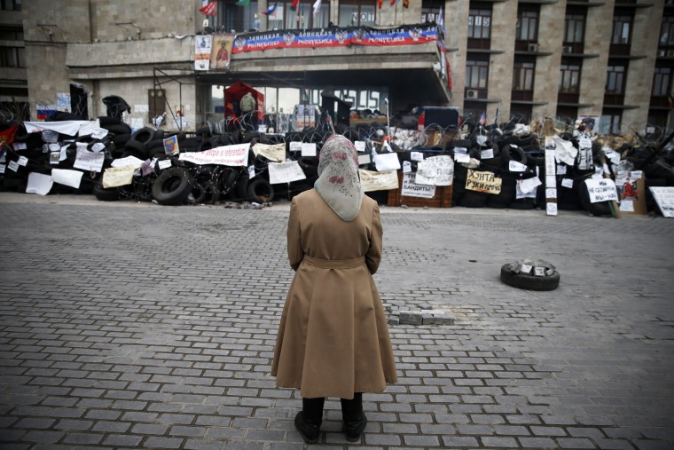 A woman stands in front of a barricade outside a regional government building in Donetsk, in eastern Ukraine, April 20, 2014.