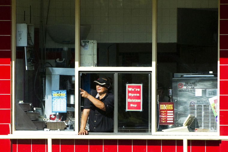 A woman working the drive-thru window at a Burger King restaurant in Kaneohe Bay, Hawaii.